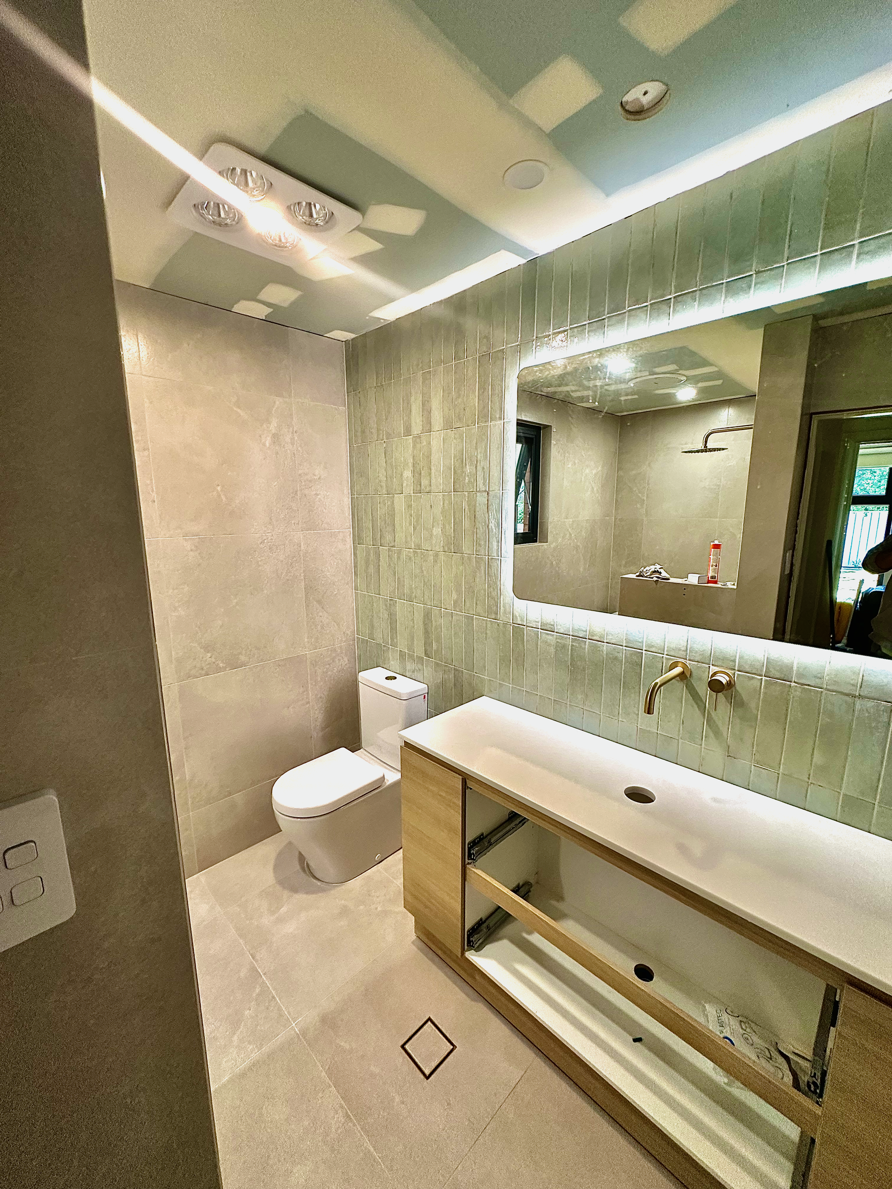 Luxury bathroom renovation with textured tiles and elegant lighting