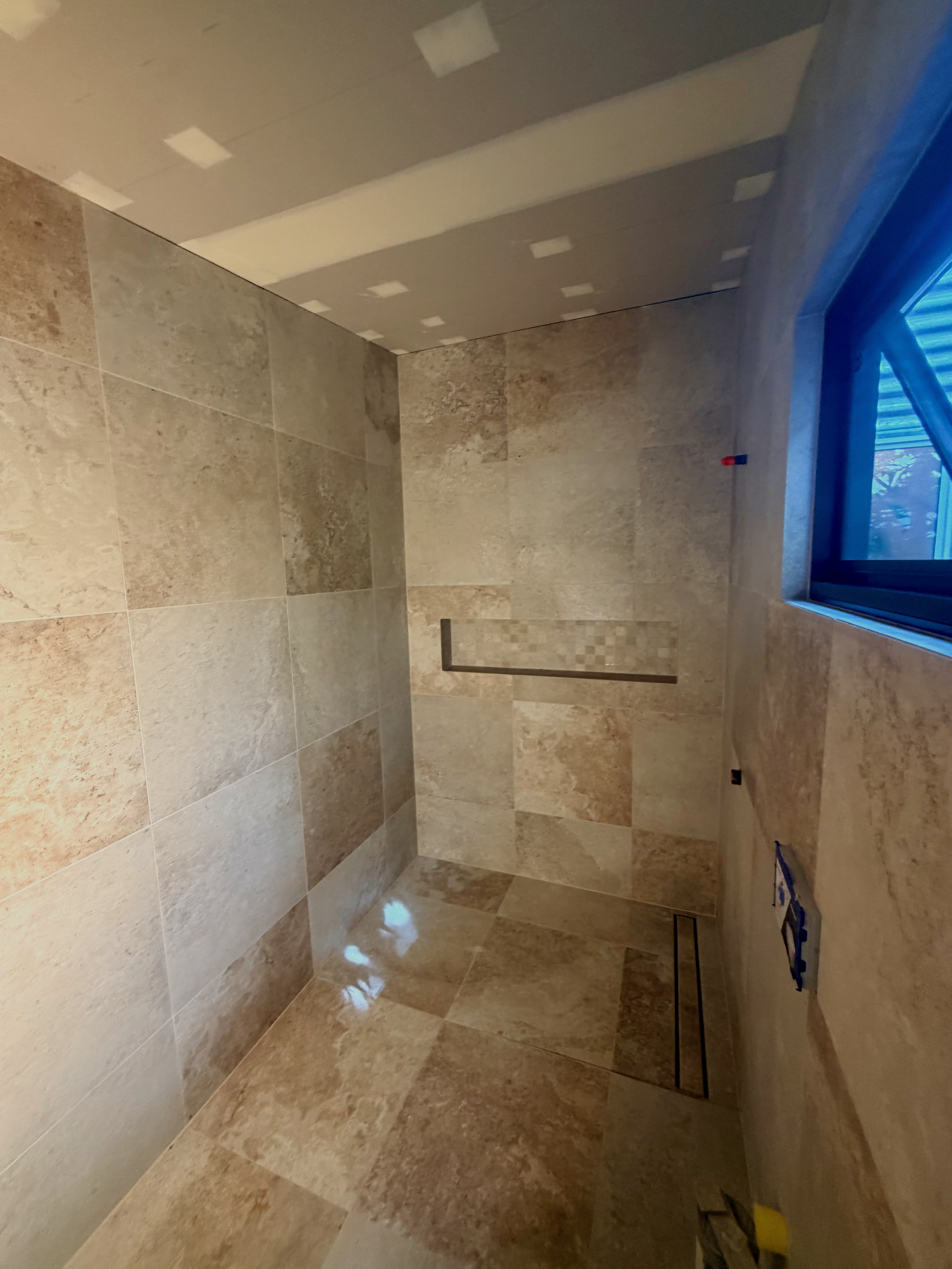 Minimalist bathroom floor and wall tiling with crisp white finishes