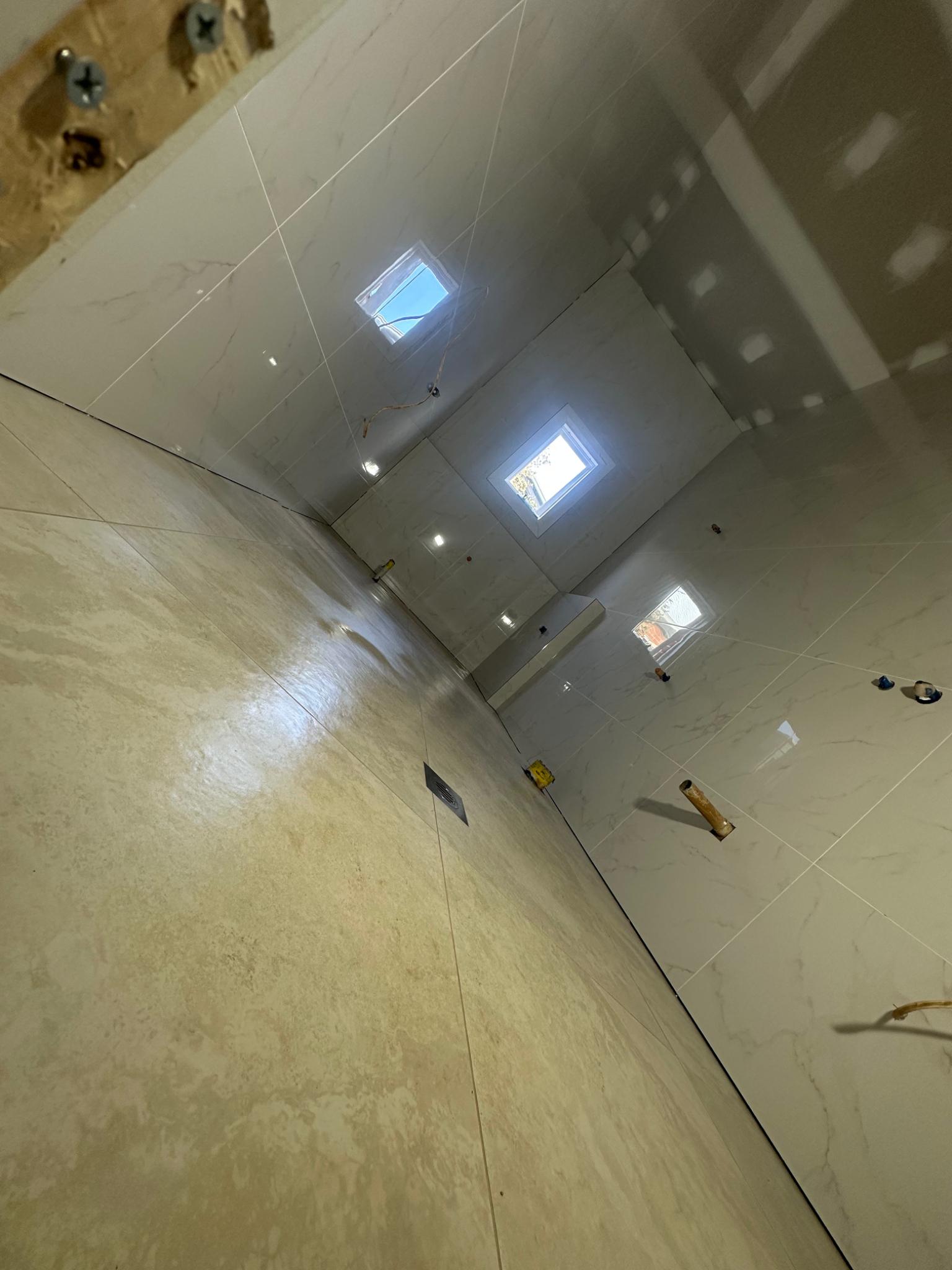 Tiling project with marble walls and beige floor in progress