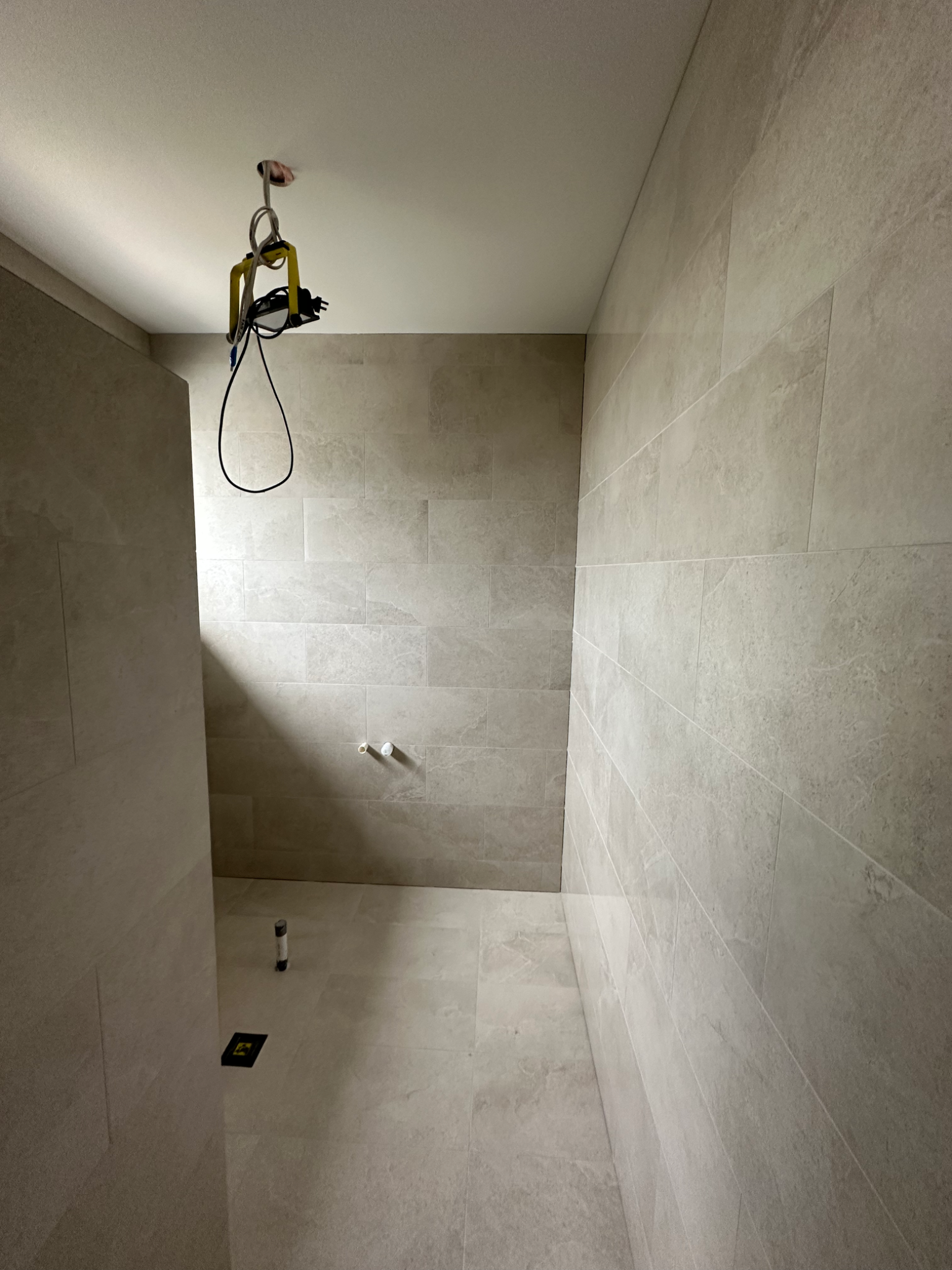 Neutral stone bathroom with beige tiles and unfinished fittings
